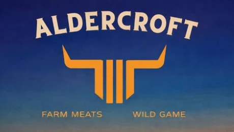 Aldercroft logo: horned emblem with the words Farm Meats and Wild Game on a dusk sky